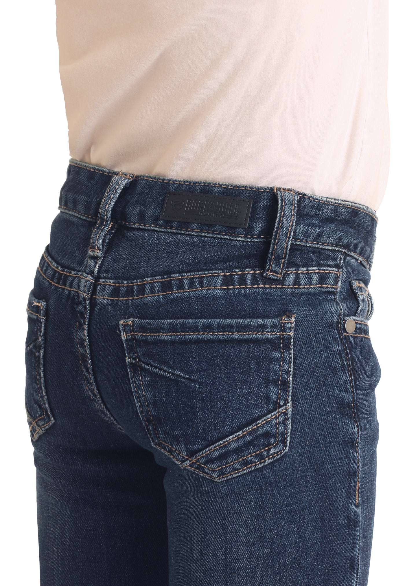 A close-up of a person wearing Rock & Roll Denim Girls' Extra Stretch Mid Rise Trouser Jeans with a light beige shirt, showcasing the stylish back pocket and waistband details of these jeans.