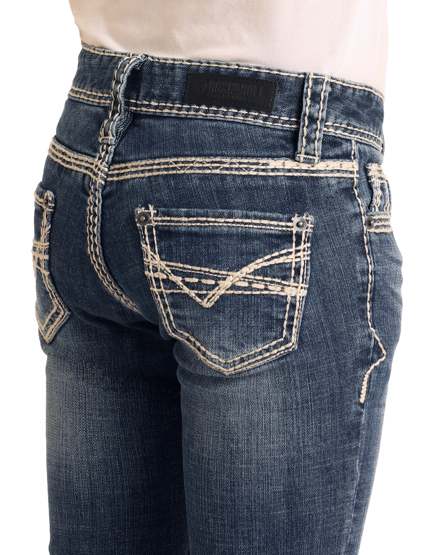 A close-up of someone wearing Rock & Roll Denim Girls' Heavy Stitch Trouser Jeans with white contrast stitching, decorative back pockets, and a black leather brand patch on the waistband.