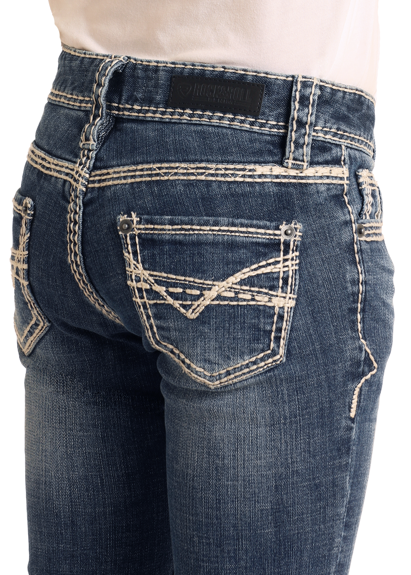 A close-up of someone wearing Rock & Roll Denim Girls' Heavy Stitch Trouser Jeans with white contrast stitching, decorative back pockets, and a black leather brand patch on the waistband.