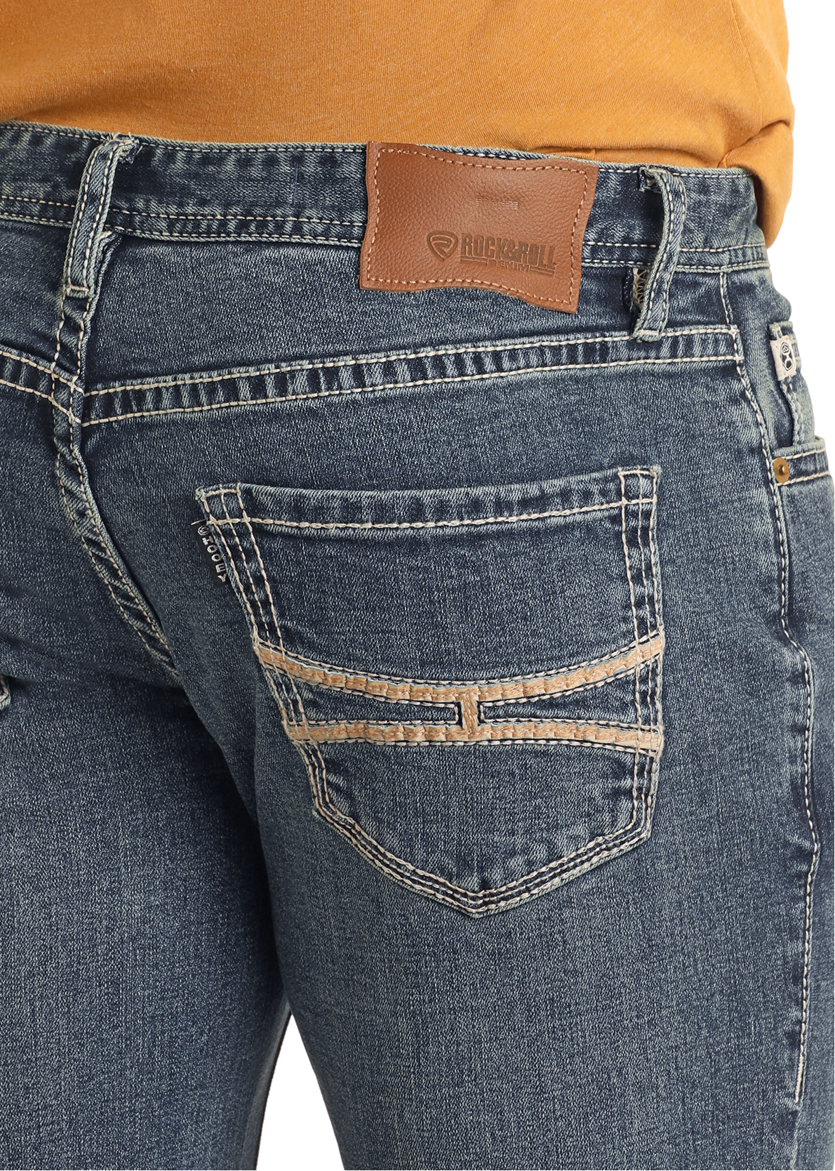 A person in Rock & Roll Denim Hooey Regular Fit Embroidery Stitch Straight Leg Jeans, featuring tan stitching, a brown leather patch waistband, and decorative back pocket embroidery, paired with a mustard yellow top.
