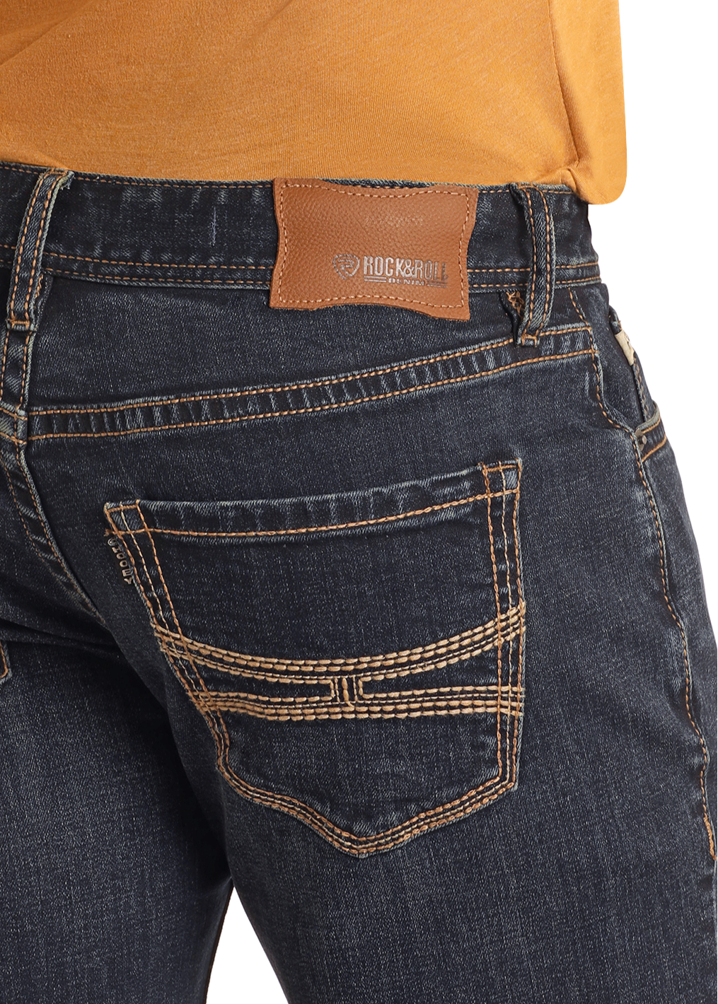 Close-up of a person wearing Rock & Roll Denim Hooey Regular Fit Two Tone Straight Leg Jeans with contrast stitching and a brown leather brand patch, paired with an orange shirt tucked in.