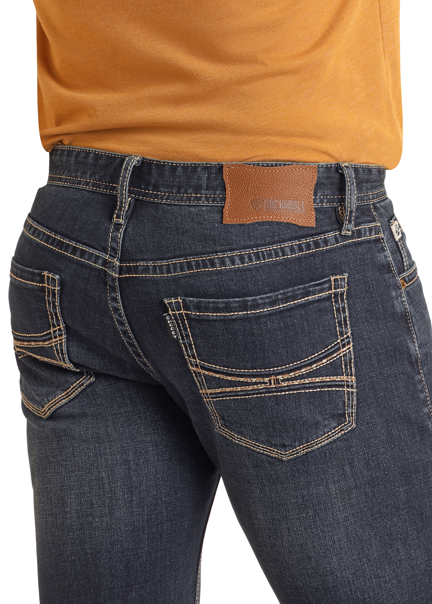 A person wears Hooey Slim Fit Barbed Stitch Straight Leg Jeans by Rock & Roll Denim, featuring beige stitching and a brown leather patch, paired with an orange shirt. The focus is on the stylish stretch jeans’ back pockets and upper area.