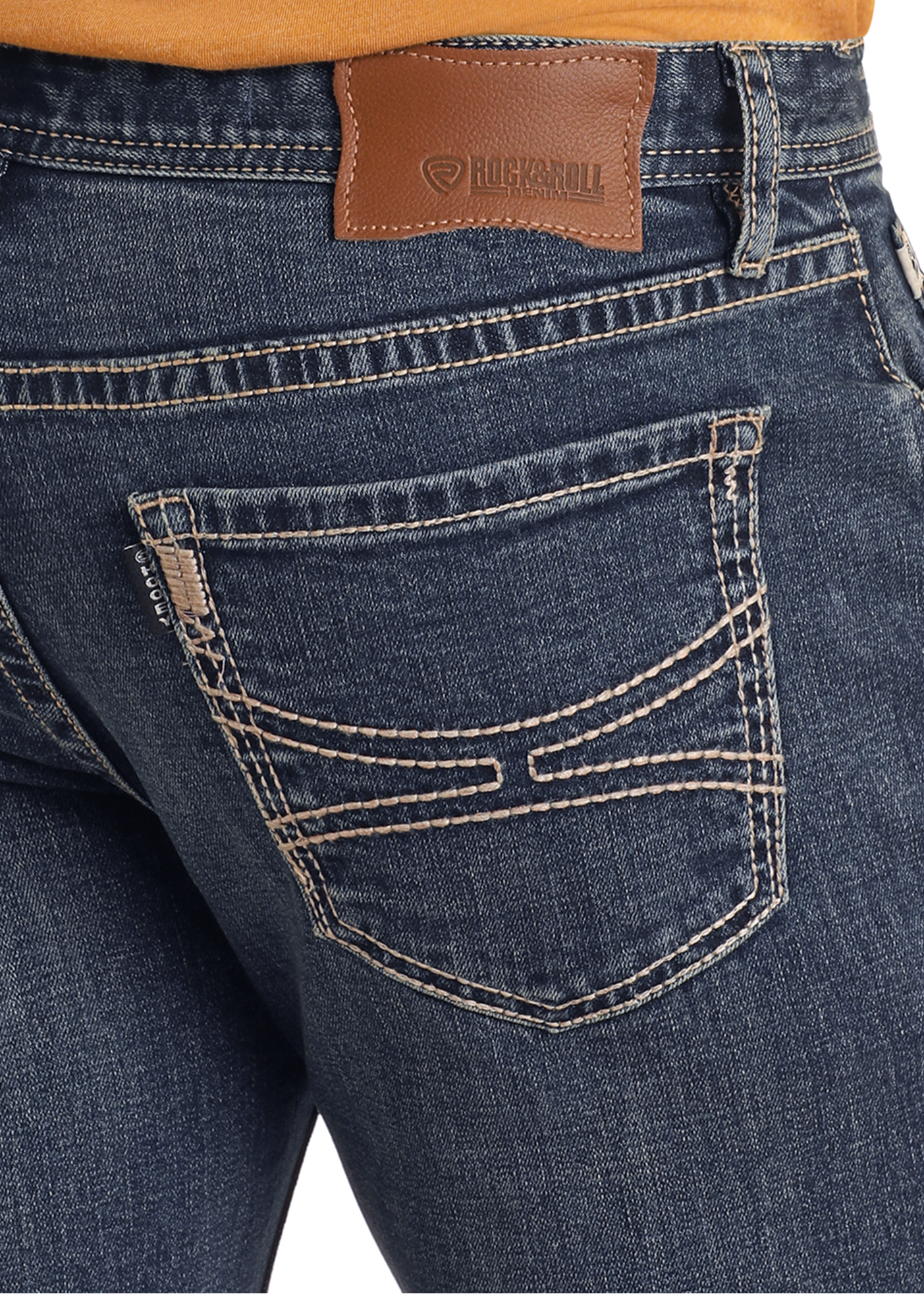 Close-up of a person wearing Rock & Roll Denim Hooey Slim Fit Curve Stitch Logo Straight Leg Jeans with tan stitching, a brown leather patch on the waistband, and decorative back pocket stitching, paired with a mustard top.