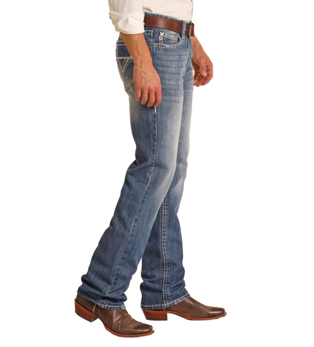 A person wearing Rock & Roll Denim Relaxed Fit Large V Straight Leg Jeans, a brown belt, brown cowboy boots, and a white shirt is shown from the waist down against a plain white background.