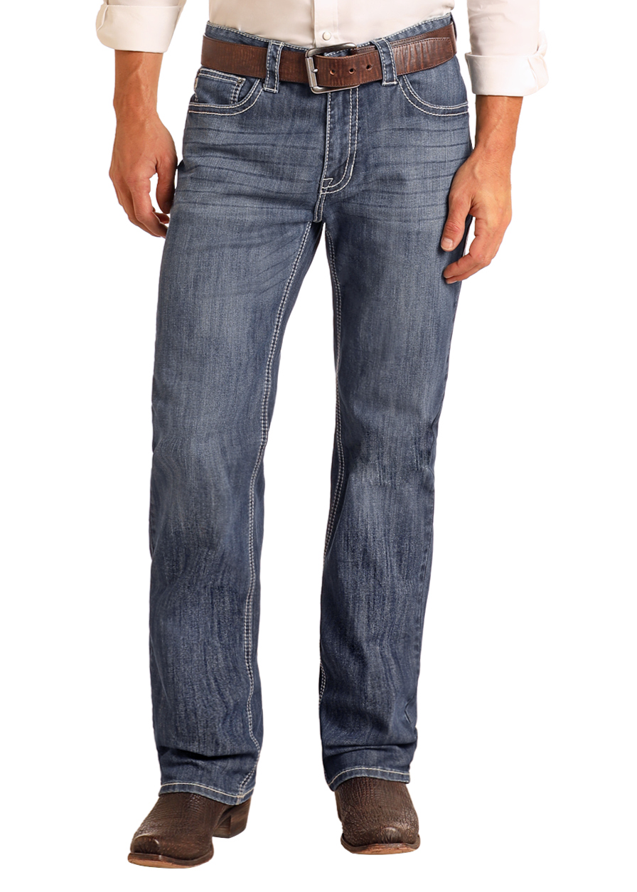 A man wearing Rock & Roll Denim Relaxed Fit Straight Leg Jeans, a brown belt, cowboy boots, and a white long-sleeve shirt stands against a plain light background.