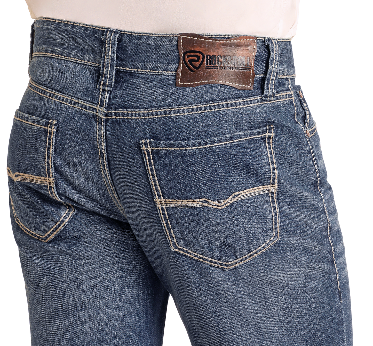 Close-up of the back of Relaxed Fit Medium Wash Straight Leg Jeans by Rock & Roll Denim, featuring tan stitching, two back pockets, and a brown leather brand patch on the waistband. The person wears a light shirt tucked in.