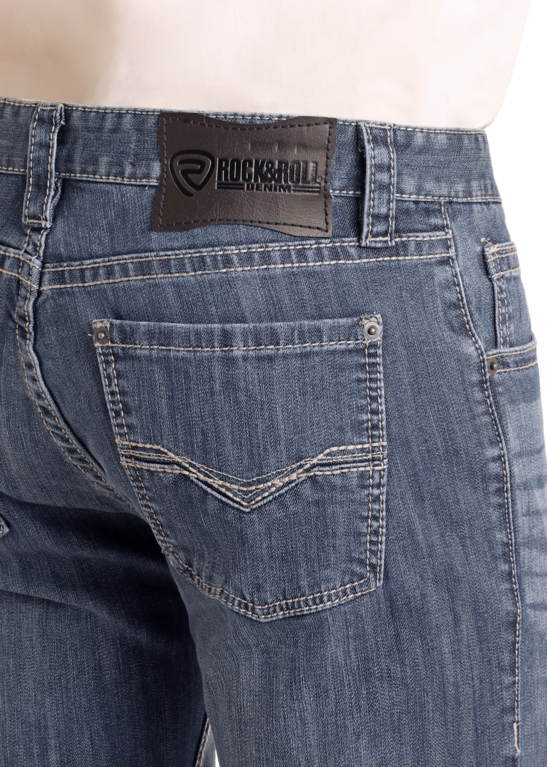 Person wearing blue Rock & Roll Denim Slim Fit Straight Leg Jeans, shown from the back waist down. Jeans have contrast stitching, two back pockets, stretch fabric for comfort, and a black leather logo patch on the waistband.
