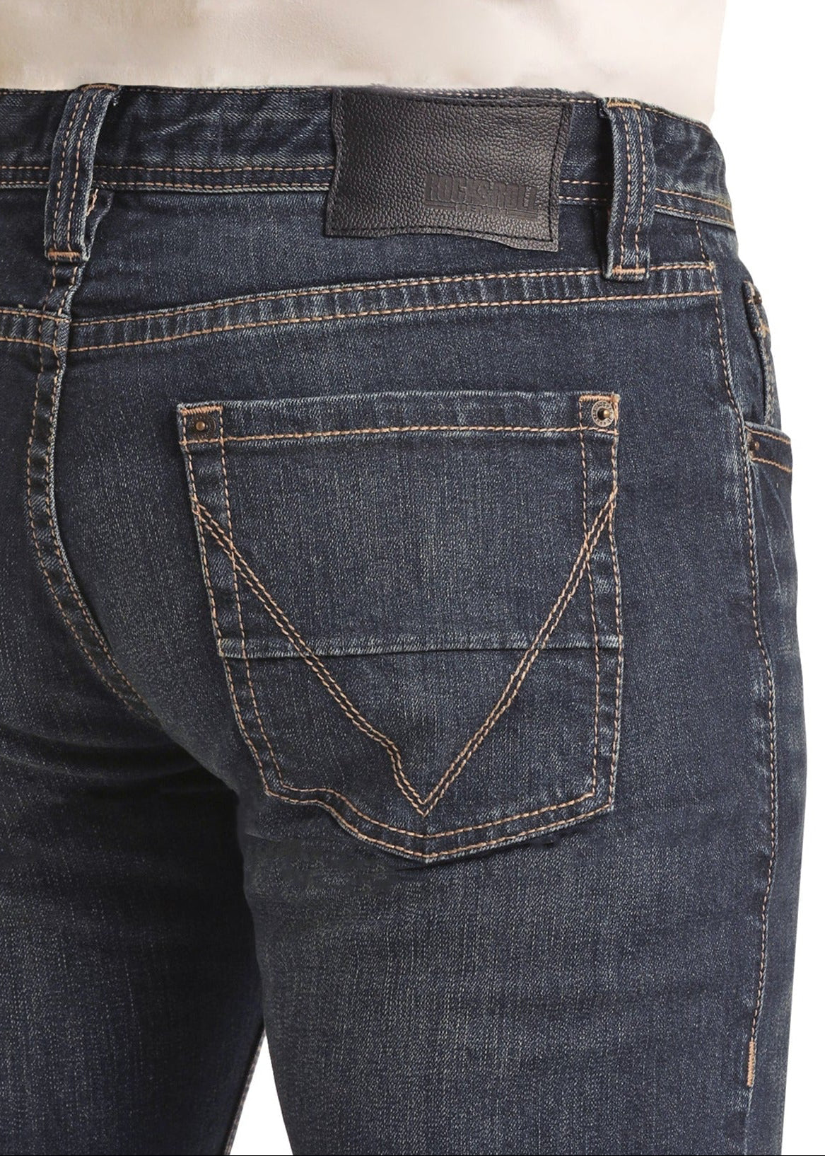 A person wearing Rock & Roll Denim’s Vintage '46 Slim Fit Straight Leg Jeans, featuring tan stitching, a black leather waistband patch, two back pockets with V-patterns, and a white shirt, shown from the back waist down.
