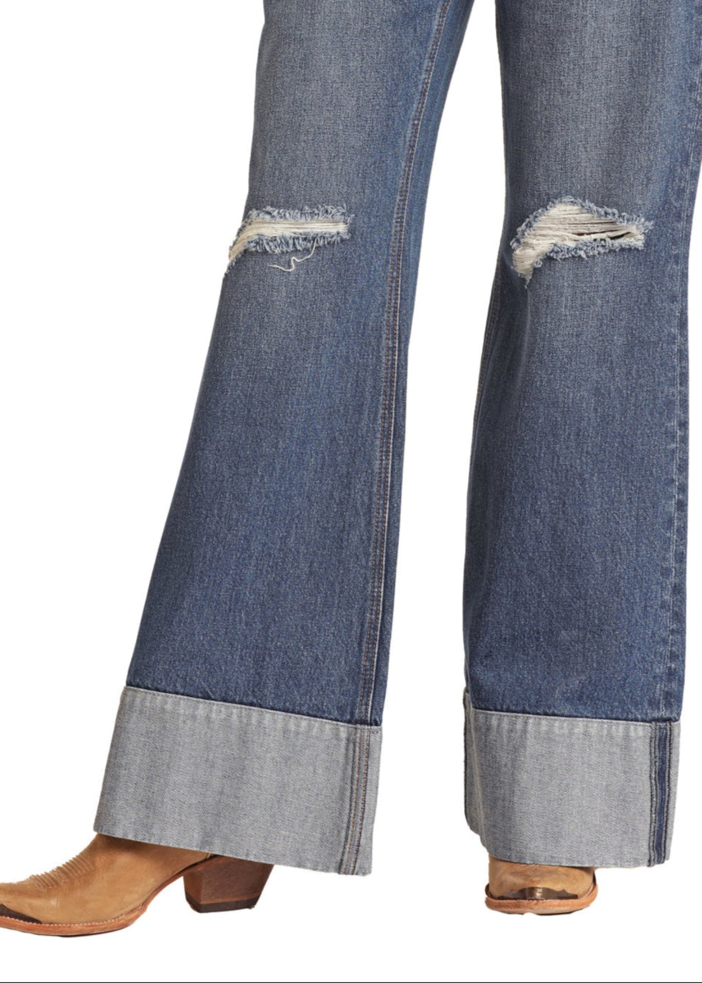 Close-up of blue jeans with distressed details on a white background