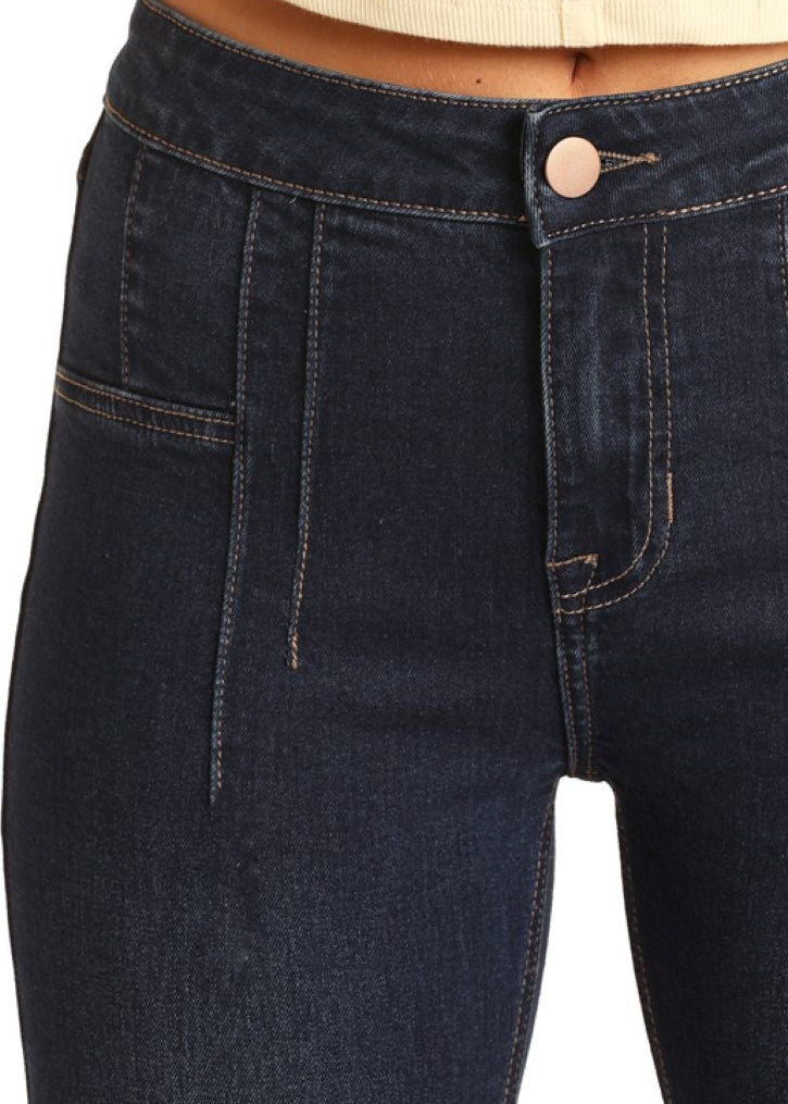 Dark blue jeans worn by a person on a white background