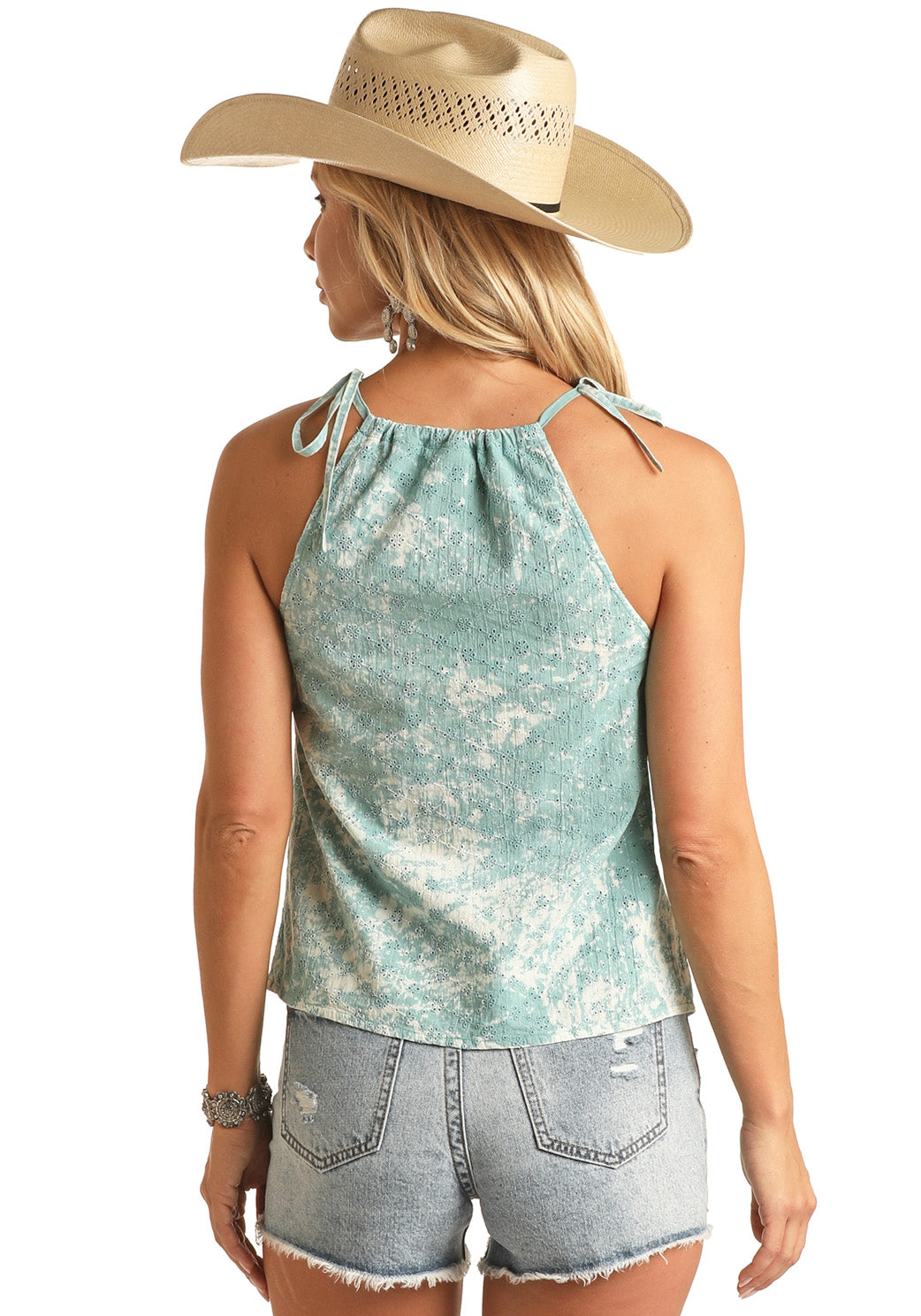 A woman shown from the back wears a straw cowboy hat, Rock & Roll Denim's Eyelet Adjustable Straps Tank Top in light blue, and distressed denim shorts.