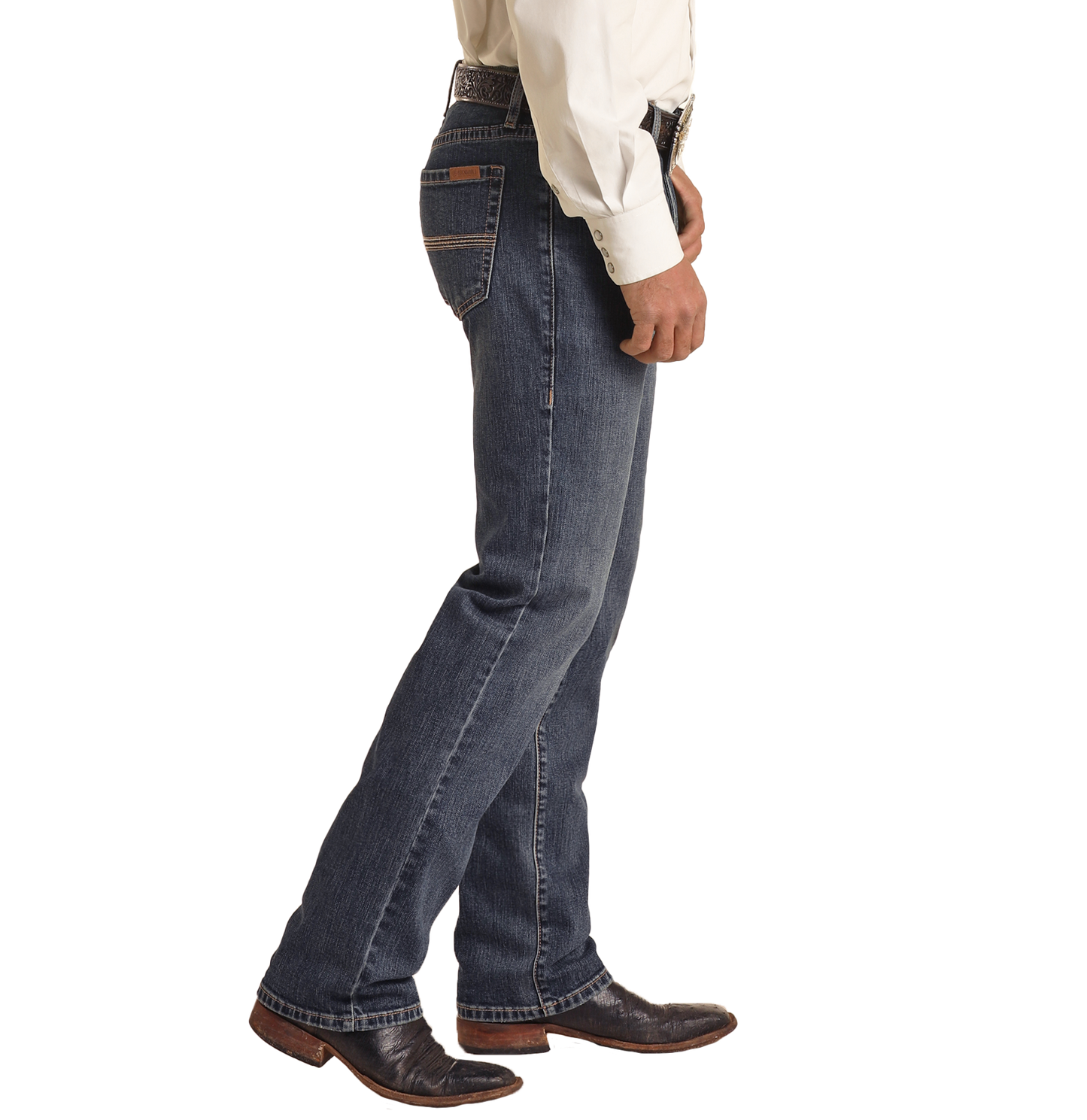A man wearing Rock & Roll Denim Vintage '46 Slim Straight Leg Jeans with two-tone pocket stitching, a cream shirt, and brown cowboy boots stands in side profile against a plain white background.
