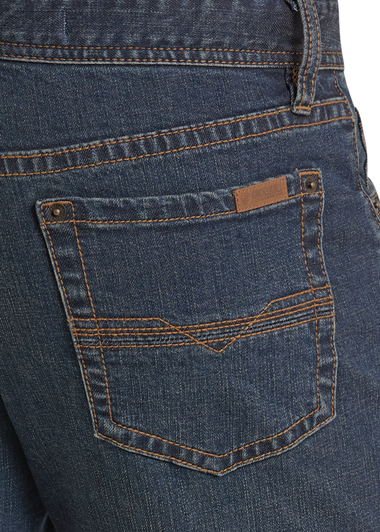 Close-up of the back pocket of dark blue denim jeans with contrast stitching and a small brown leather brand patch.