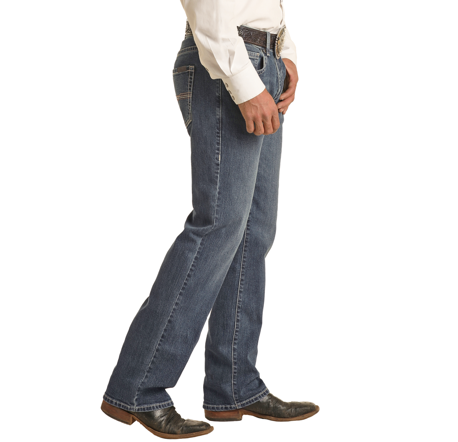A person wearing Rock & Roll Denim Vintage '46 Regular Fit Stackable Bootcut Jeans, a white dress shirt, and black cowboy boots stands sideways with one hand resting on their belt.