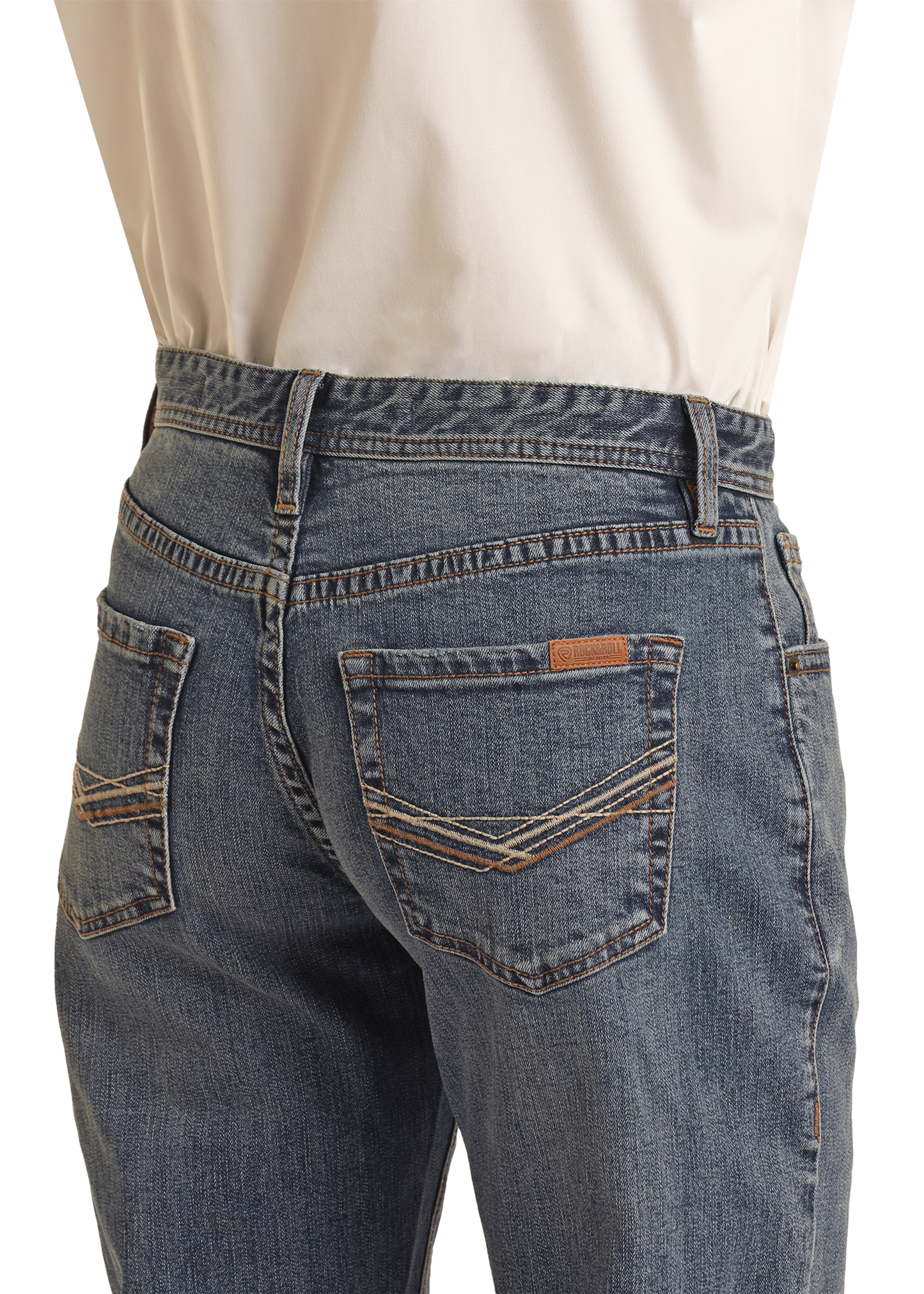 A person, shown from the waist down and viewed from the back, wears a tucked-in cream shirt and Rock & Roll Denim’s Vintage '46 Relaxed Stackable Bootcut Jeans with two-tone embroidered back pockets.