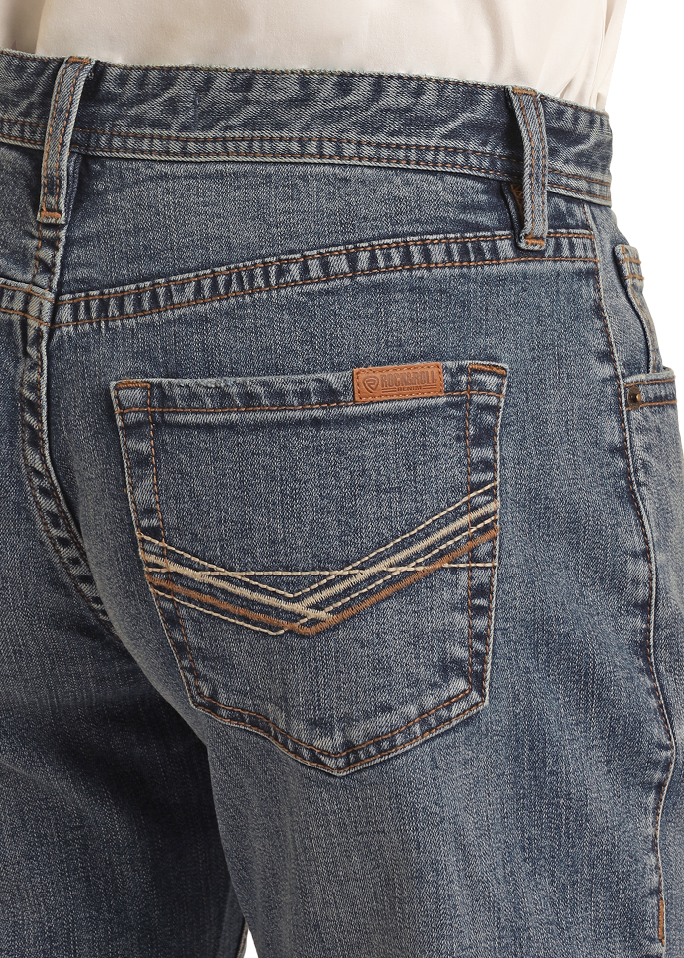 A person, shown from the waist down and viewed from the back, wears a tucked-in cream shirt and Rock & Roll Denim’s Vintage '46 Relaxed Stackable Bootcut Jeans with two-tone embroidered back pockets.