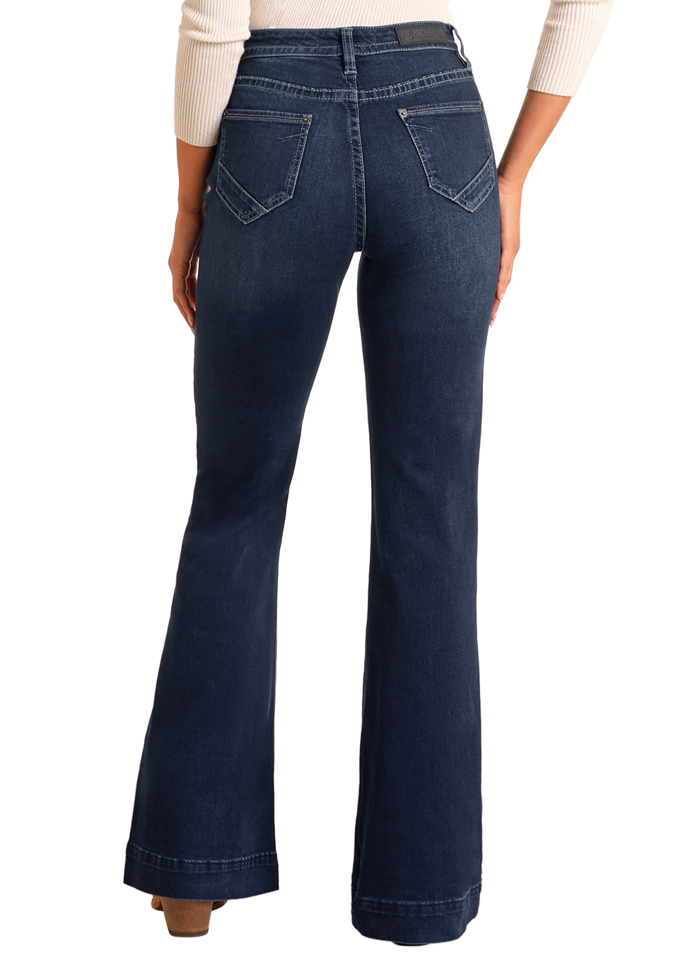 Someone is shown from the back against a plain white background, wearing Rock & Roll Denim’s Button Fly High Rise Trousers in dark blue with a slim fit, paired with a light-colored long sleeve top.