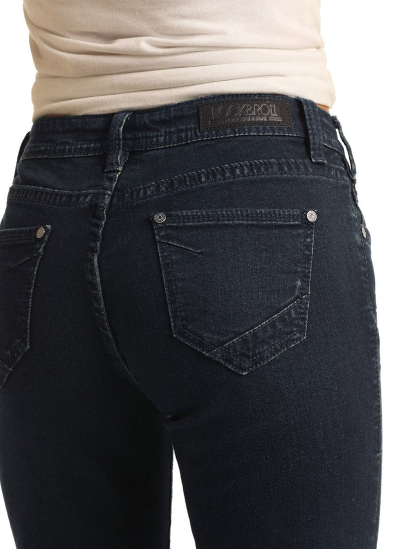 A close-up of a person wearing Rock & Roll Denim’s Mid Rise Extra Stretch Trousers in dark blue with a light beige top, focusing on the jeans’ back pockets and waistband.