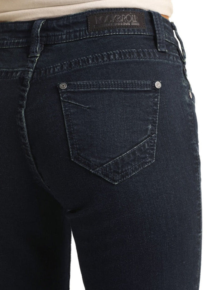A close-up of a person wearing Rock & Roll Denim’s Mid Rise Extra Stretch Trousers in dark blue with a light beige top, focusing on the jeans’ back pockets and waistband.