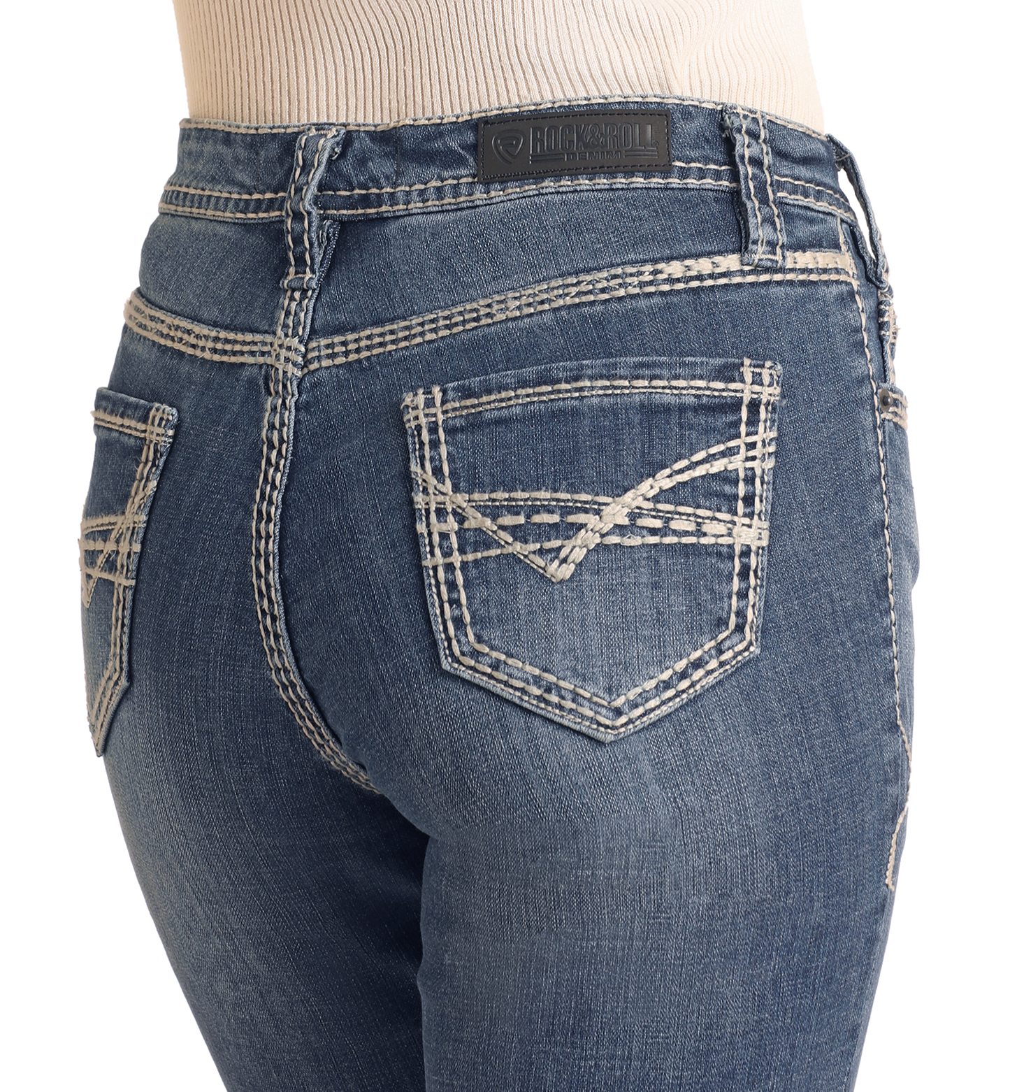 Close-up of a person wearing Rock & Roll Denim's Mid Rise Petal Stitch Trousers, featuring white double-stitching on the back pockets and waistband, a black leather brand patch, and a light ribbed top tucked in.