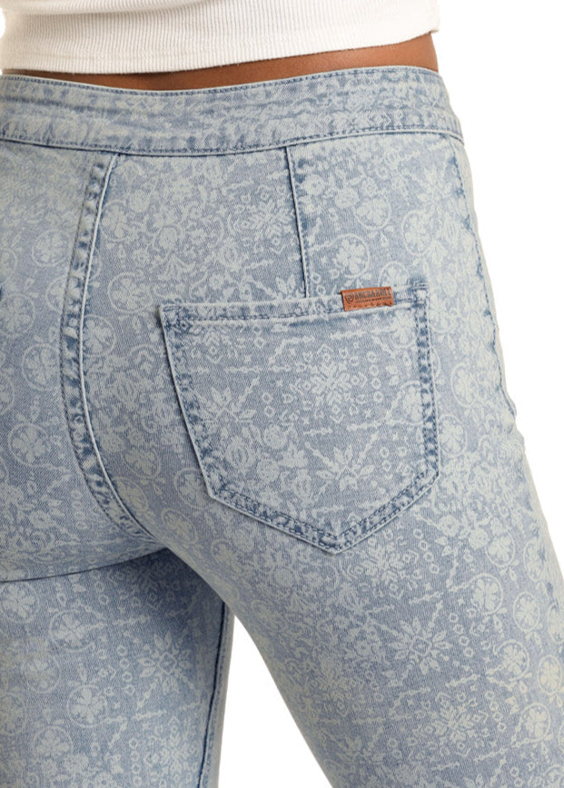 A person wearing Rock & Roll Denim’s Aztec Pattern High Rise Bell Bottom Jeans, shown from the waist down against a white background.