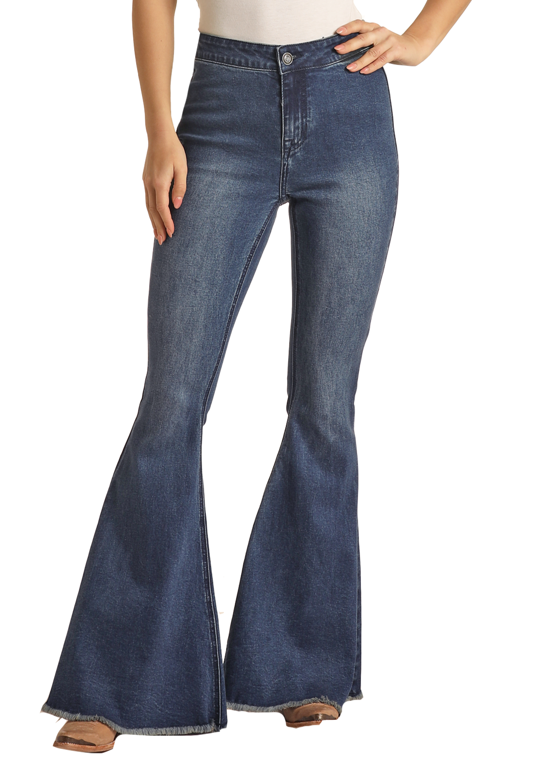 A woman stands confidently with one hand on her hip against a white background, wearing Rock & Roll Denim's Dark Wash High Rise Bell Bottoms featuring stretch denim and a raw hem, paired with tan shoes.