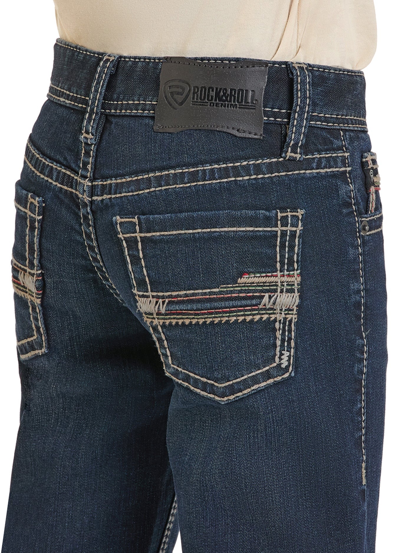 Close-up of the back of a person wearing Rock & Roll Denim Boys' Slim Fit Dark Straight Leg Jeans, with white stitching, striped detail on the back pocket, and a visible brand label on the waistband.