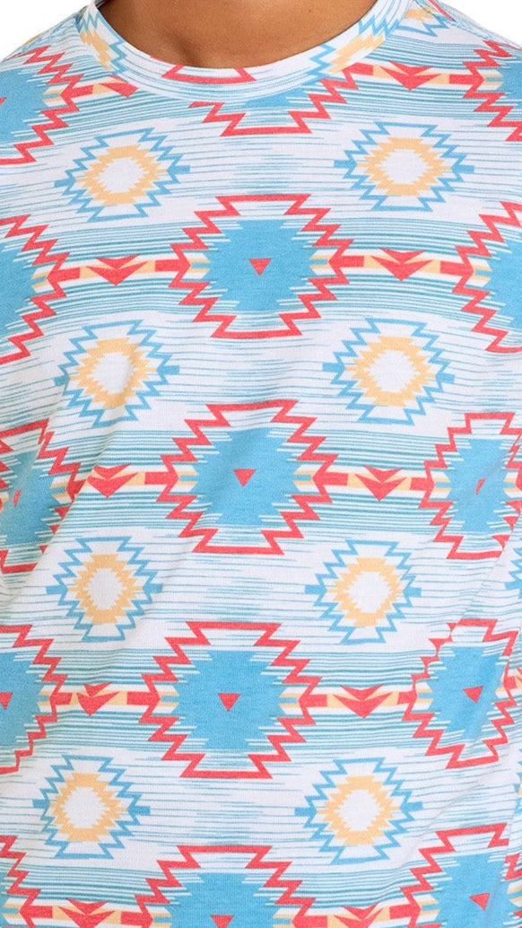 The Rock & Roll Denim Boys' Aztec Printed Tee showcases a bold geometric pattern with blue, red, yellow, and white zigzags and diamond shapes in horizontal rows.