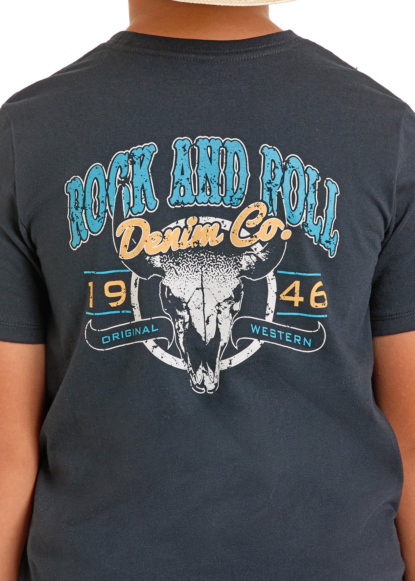 A boy wears the Rock & Roll Denim Boys' 1946 Graphic Tee, featuring a steer skull and bold graphics—perfect for showcasing an adventurous spirit.