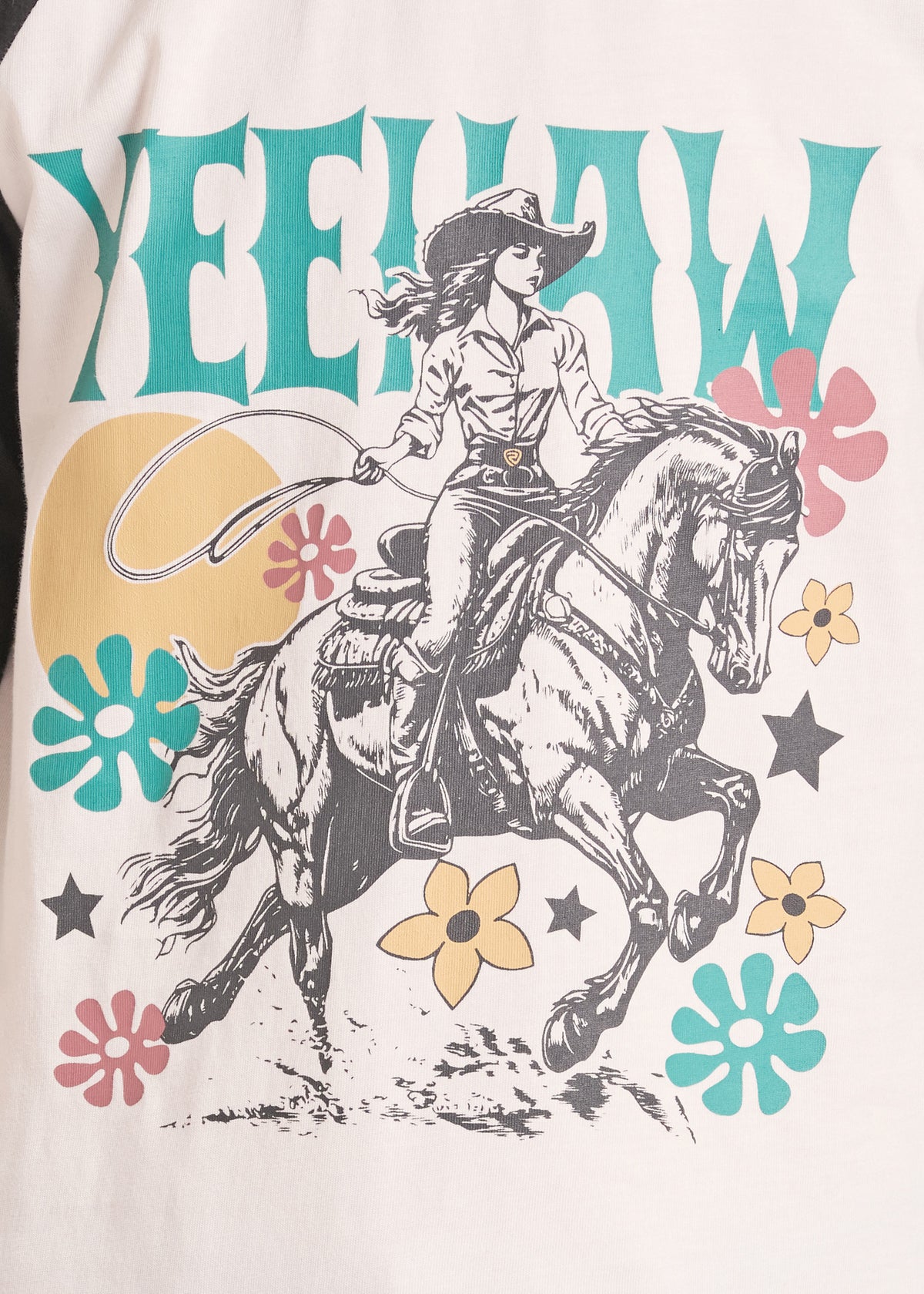 A close-up of a graphic t-shirt featuring a western theme. The design shows a black and white illustration of a cowboy riding a galloping horse, with the word 'YEEHW' in teal letters across the top, surrounded by retro-style teal, pink, and yellow flowers and stars on a cream-colored fabric.