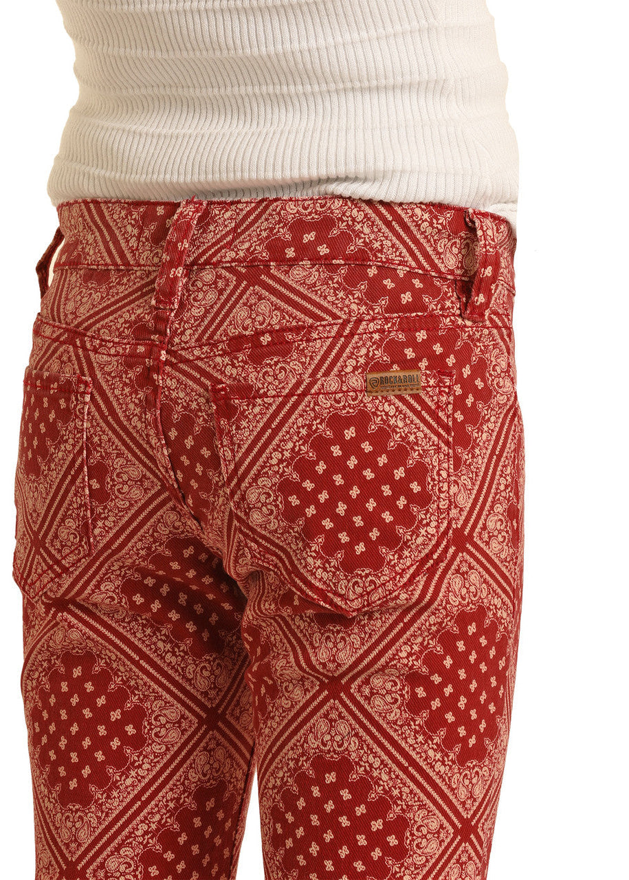 A person wearing Rock & Roll Denim Girls' Bandana Print Flare Jeans and a white ribbed top. The image focuses on the waist and upper thighs, showcasing the western-inspired bandana pattern and unique design.