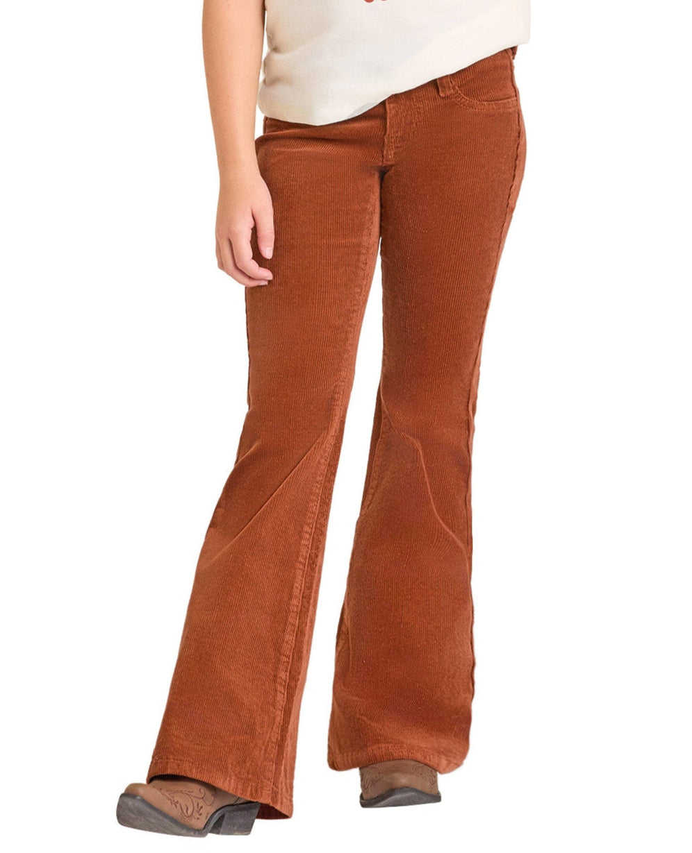 A girl wears Rock & Roll Denim Girls' Rust Corduroy Flare Jeans with a cream top and brown boots, capturing cowgirl style; she’s shown from the shoulders down against a white background.