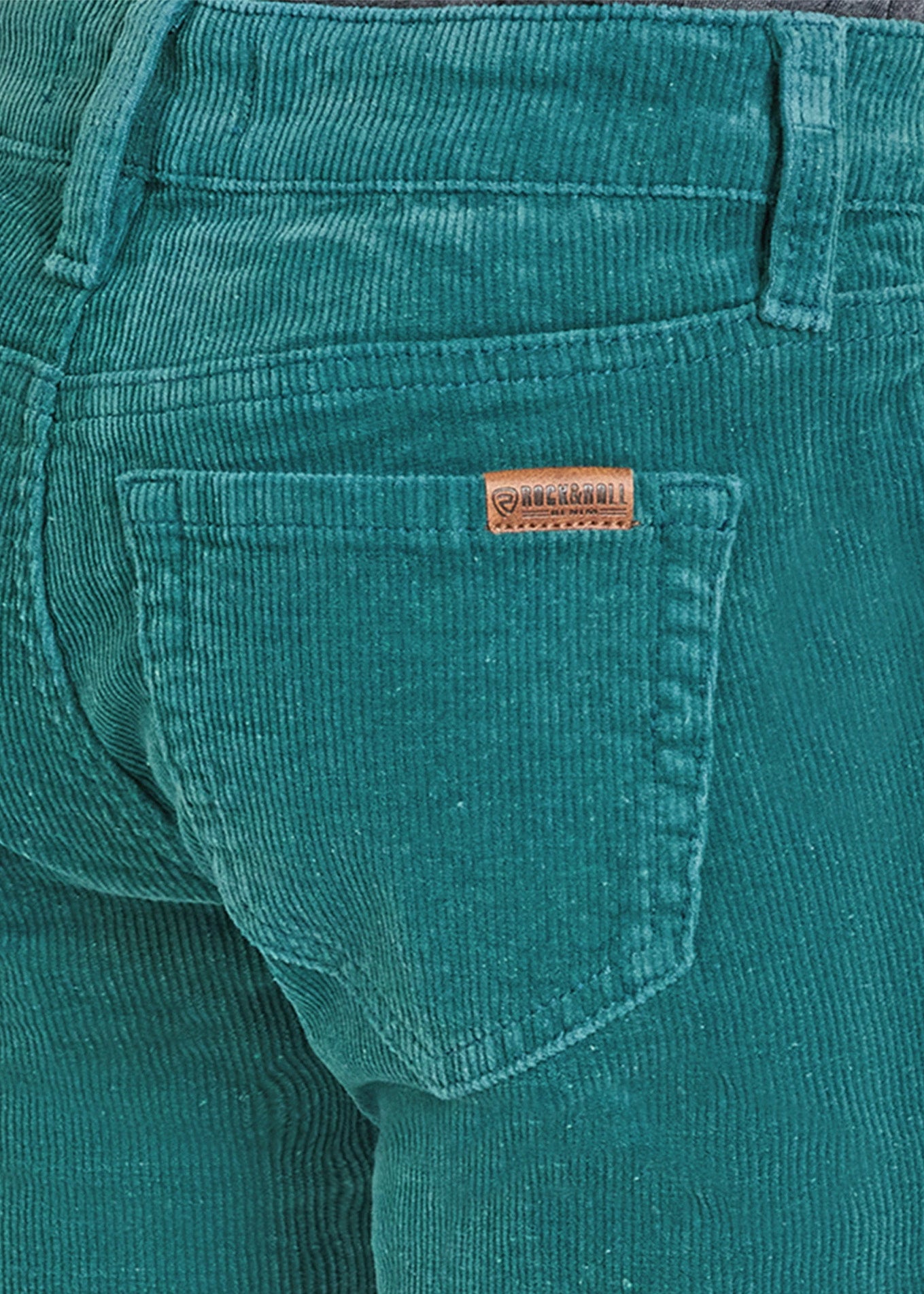Teal corduroy pants with a brand label on the pocket