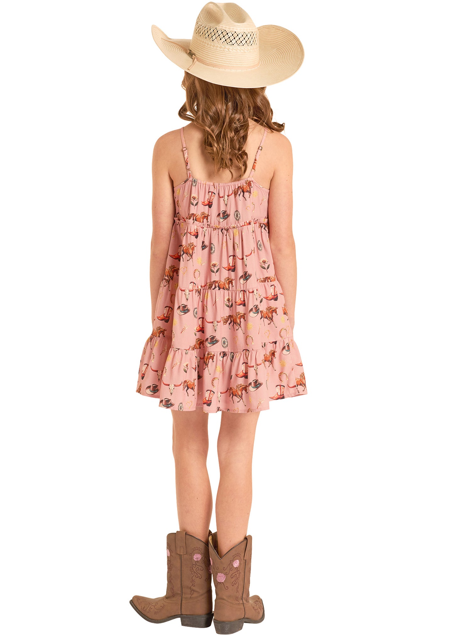 Person wearing a pink floral dress, beige cowboy hat, and brown boots on a white background
