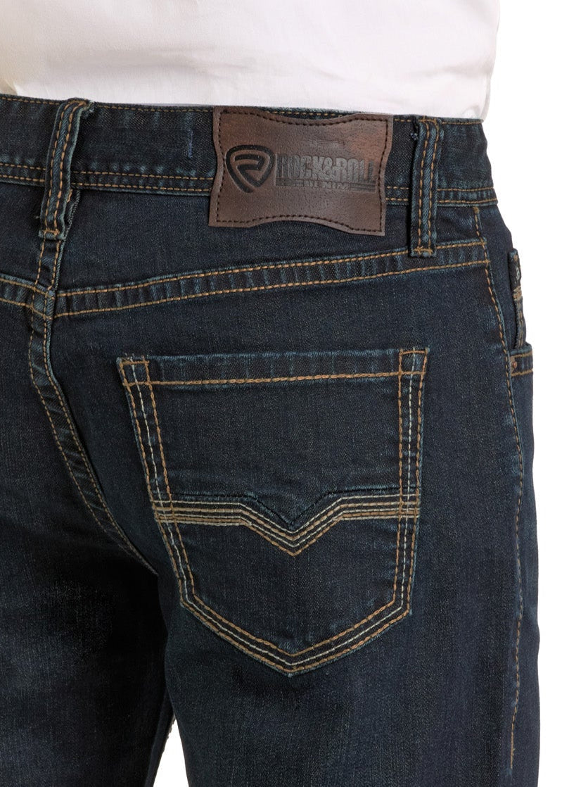 Close-up of a person wearing Rock & Roll Denim's Relaxed Fit Flat Seam Pocket Straight Leg Jeans with contrasting stitching and a leather waistband patch, paired with a white shirt tucked in.