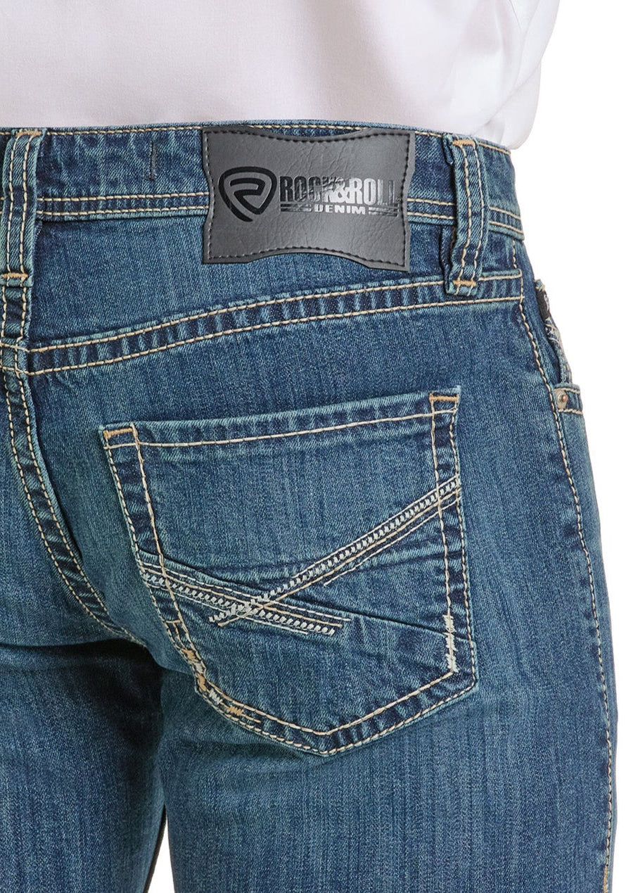 Back view of a person wearing Rock & Roll Denim Regular Fit Cross Embroidered Straight Leg Jeans, featuring pocket embroidery and a black leather brand patch by the waistband. The tucked-in white shirt adds to the classic style.