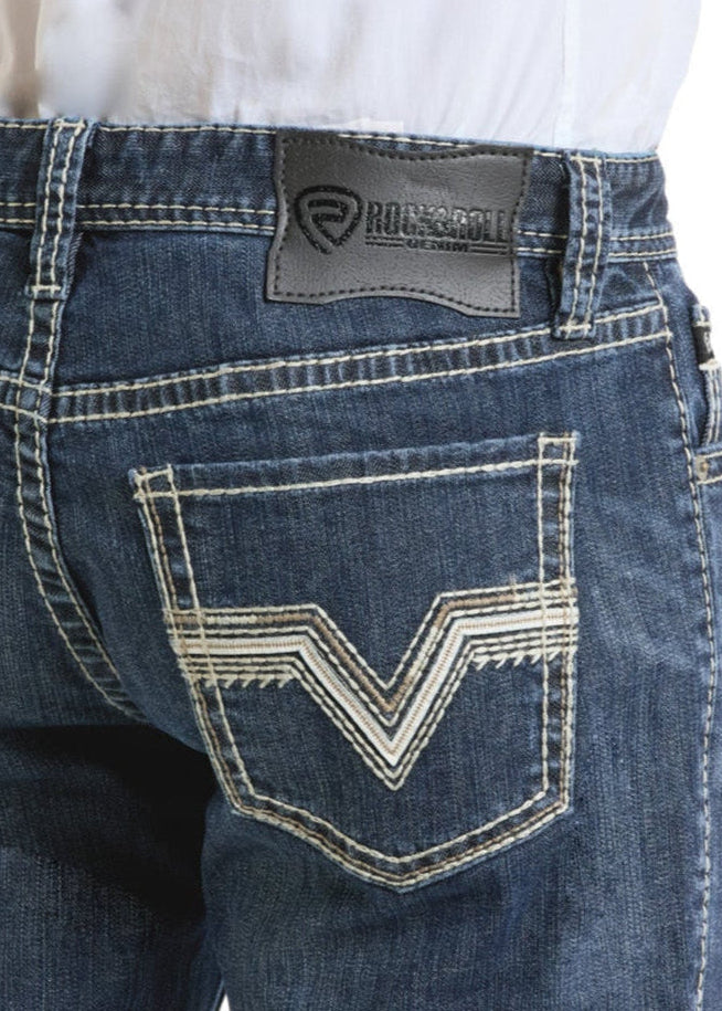Person shown from the waist down and back, wearing Rock & Roll Denim Slim Fit Zigzag Pocket Straight Leg Jeans with heavy white stitching and a black leather brand patch on the waistband.