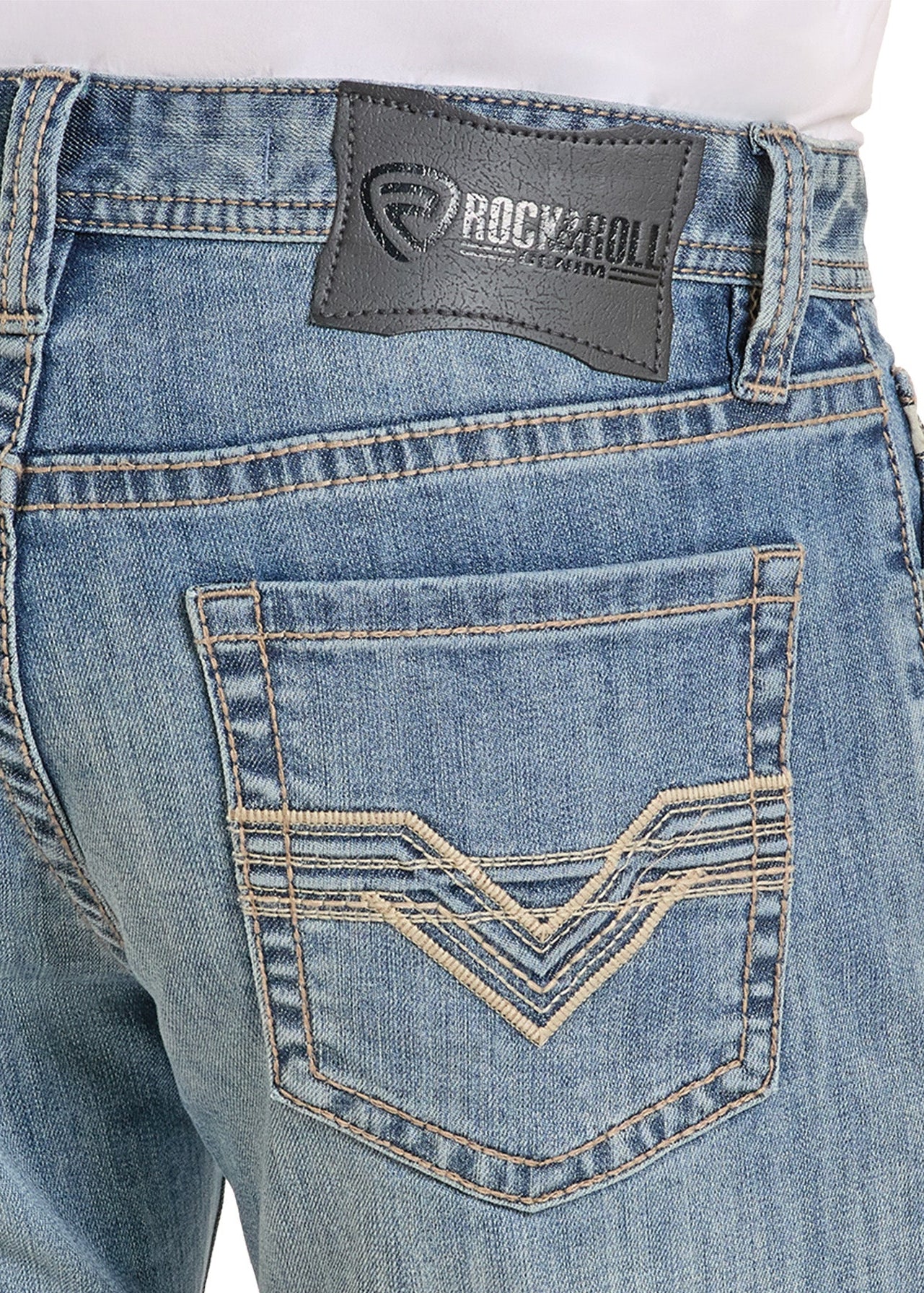 Close-up of blue jeans with a Rock & Roll denim label on a white background