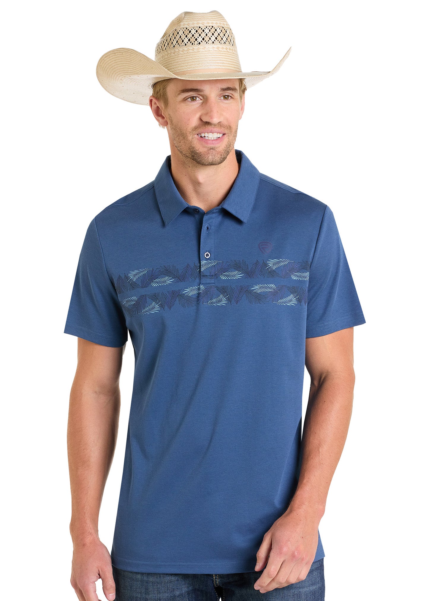 A man in a straw cowboy hat and a Rock & Roll Denim Palm Border Polo, featuring a feather-like chest pattern, stands smiling with his hands relaxed at his sides.