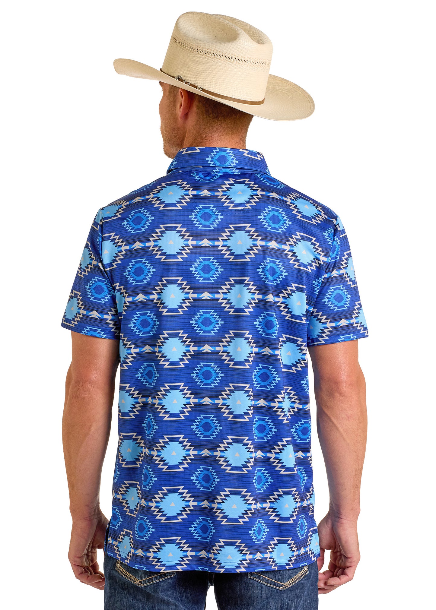 A man in a tan cowboy hat and the Rock & Roll Denim Bold Blue Aztec Polo, featuring a geometric pattern, stands with his back to the camera, displaying the shirt and blue jeans.