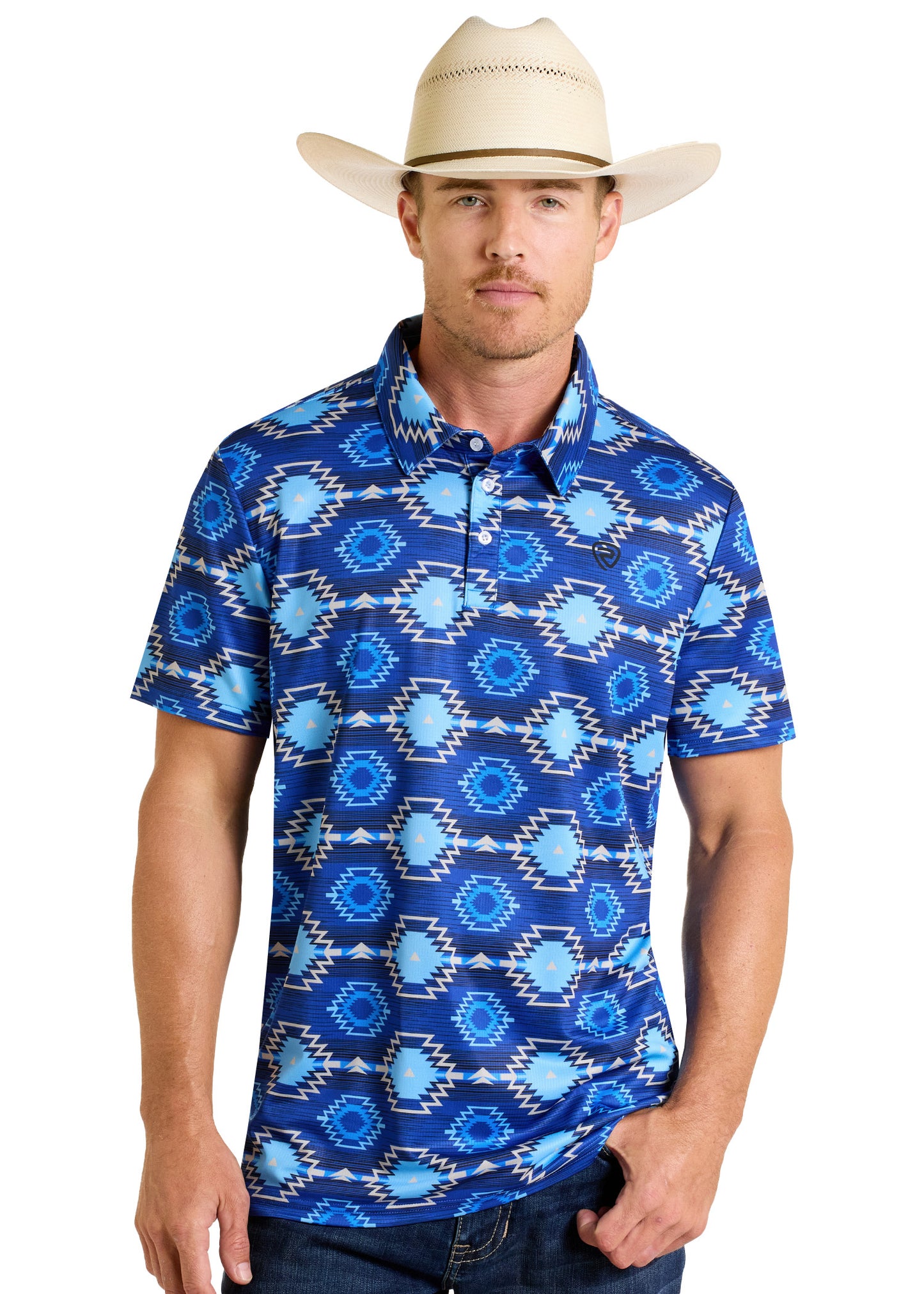 A man in a Rock & Roll Denim Bold Blue Aztec Polo and a cream cowboy hat stands facing forward with one hand in his pocket against a white background.