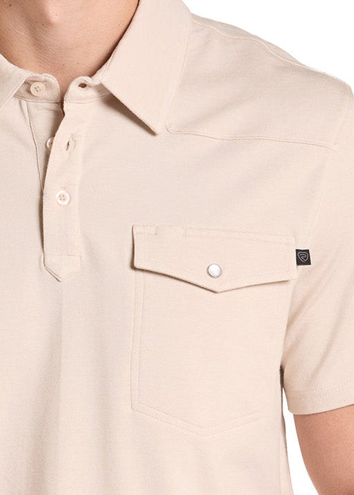 A man wearing a beige short-sleeve polo shirt with a chest pocket