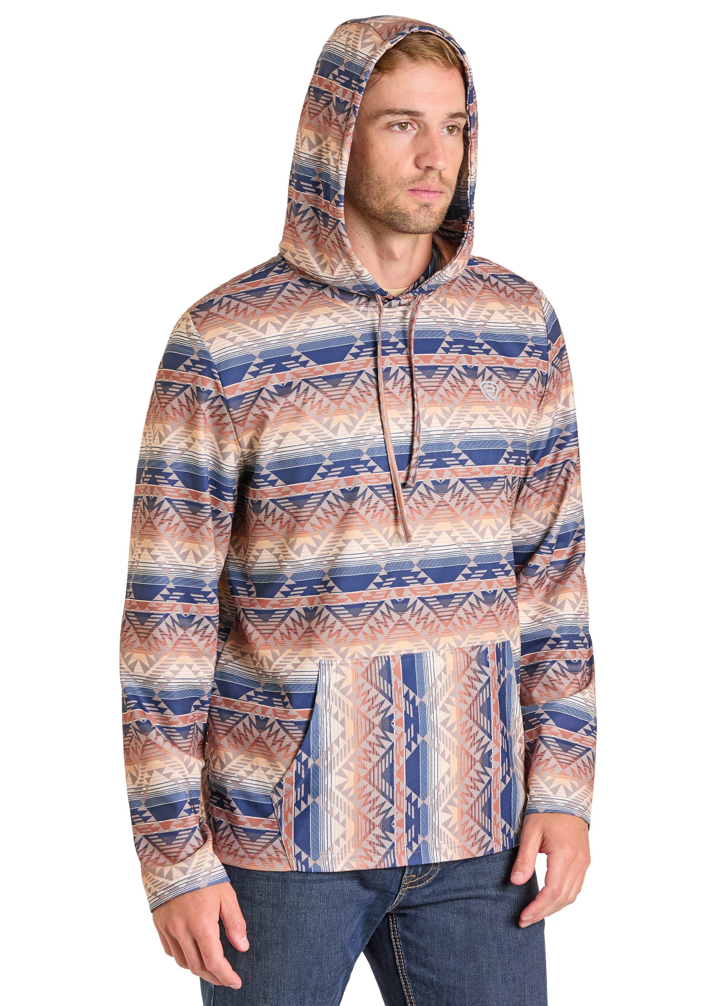 A man stands casually with his hands at his sides, wearing the Rock & Roll Denim Aztec Stripe Performance Hoodie featuring blue, beige, and brown geometric patterns, paired stylishly with classic blue jeans.