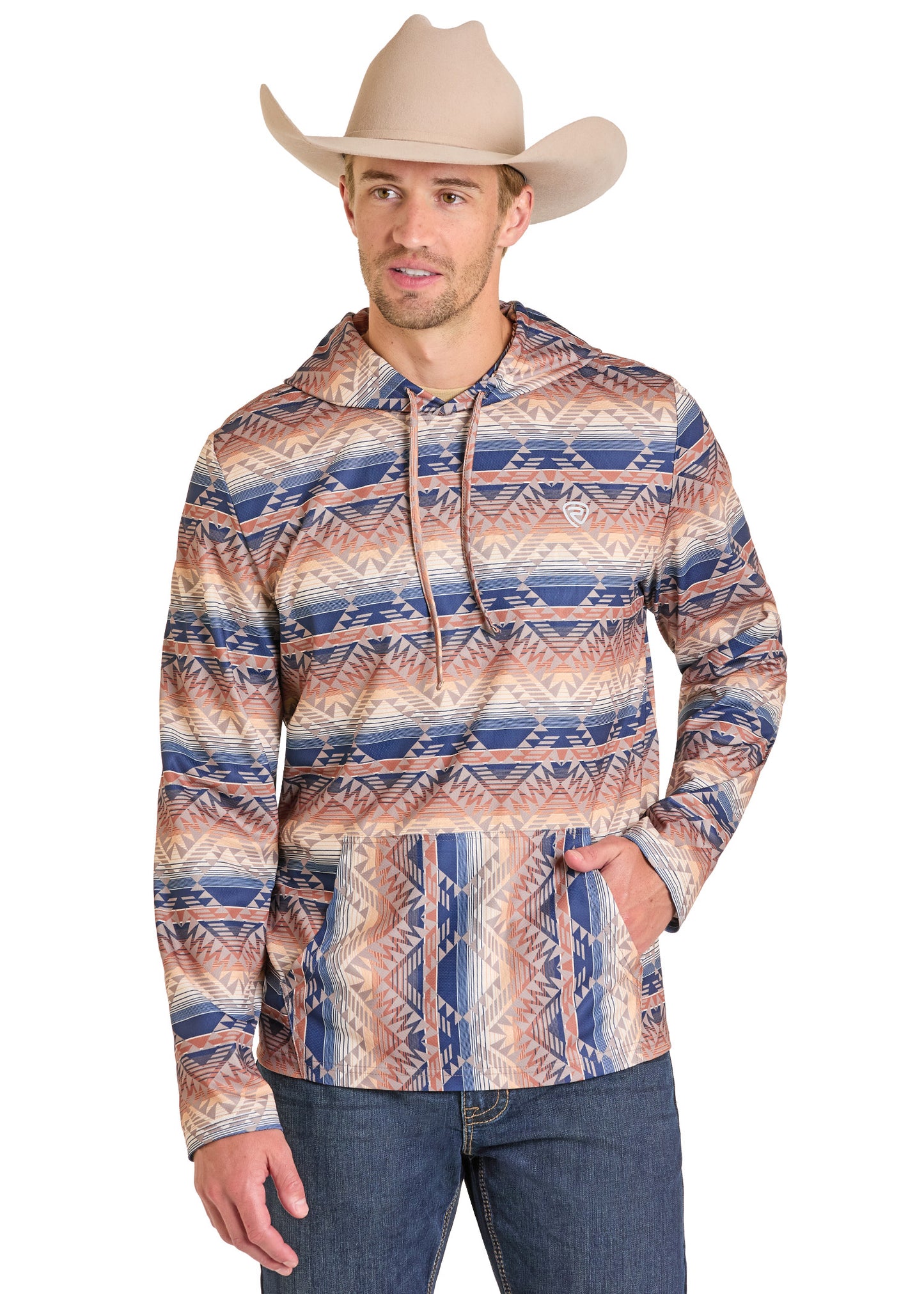 A man in a beige cowboy hat and the Rock & Roll Denim Aztec Stripe Performance Hoodie—featuring blue, beige, and brown geometric designs—stands with one hand in his pocket, blending style and comfort effortlessly.