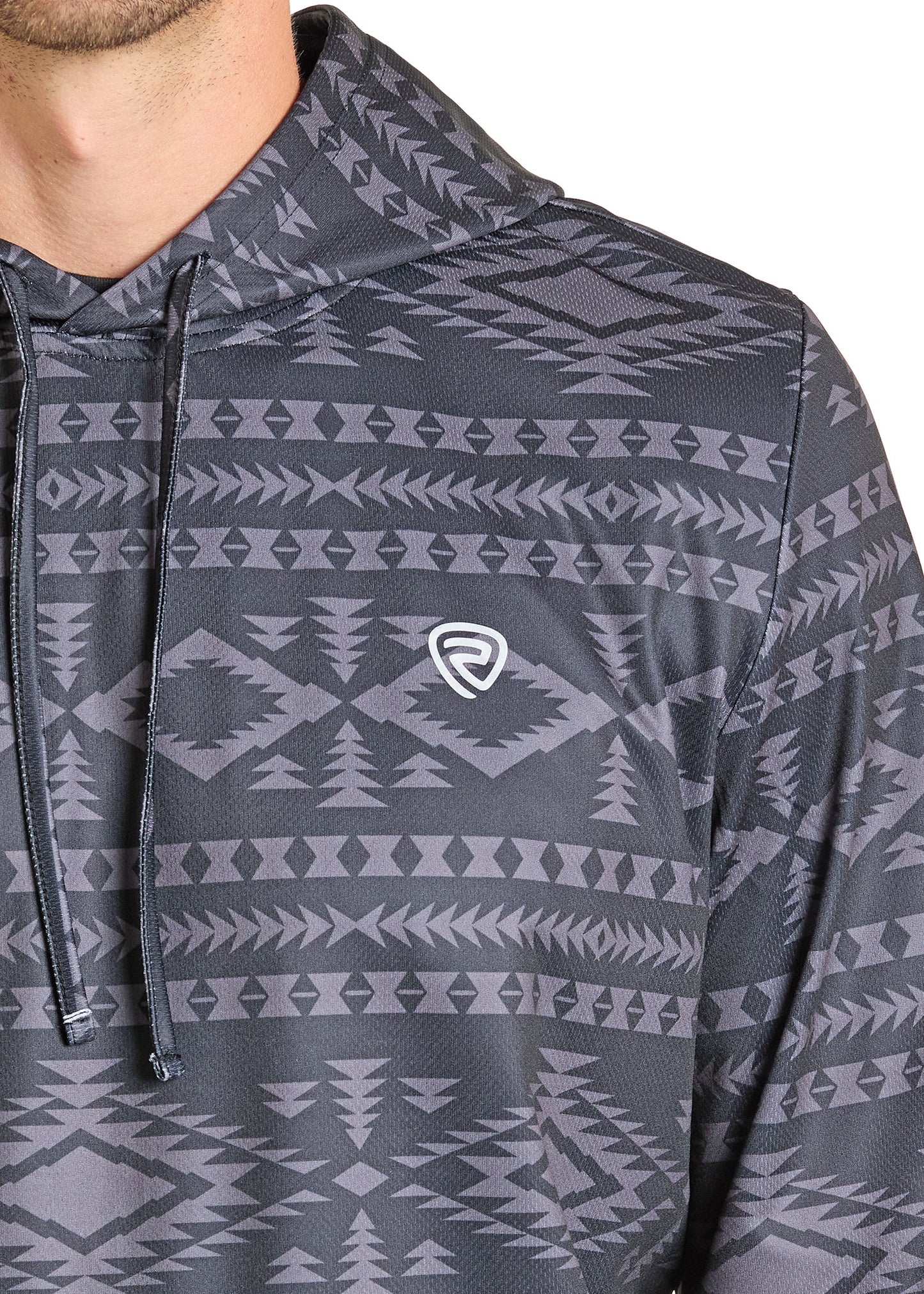 Close-up of a person wearing the Rock & Roll Denim Black Aztec Performance Hoodie, featuring a gray geometric tribal pattern and small white chest logo. Only the lower face and upper torso are shown, highlighting its stylish comfort.