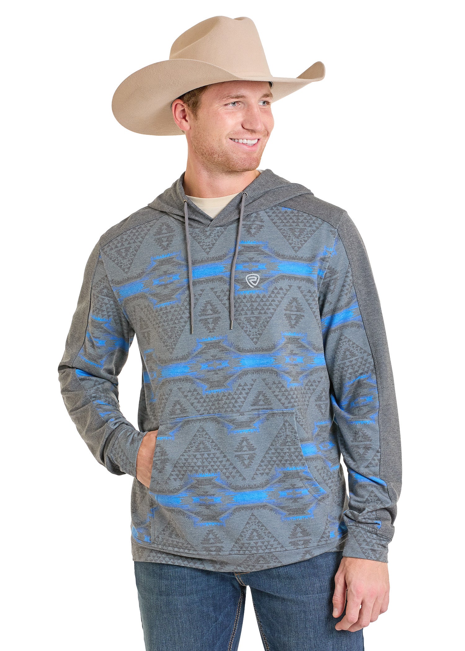 A man wears a tan cowboy hat, blue jeans, and the Rock & Roll Denim Grey Aztec Performance Hoodie with a front pocket, smiling as he looks to his left.