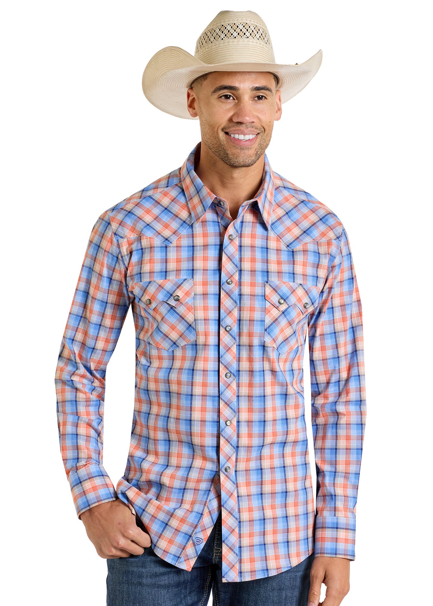 A man wearing a white cowboy hat, Rock & Roll Denim Slim Fit Dobby Plaid Long Sleeve Snap Shirt in blue, red, and white, and blue jeans smiles while standing against a white background.