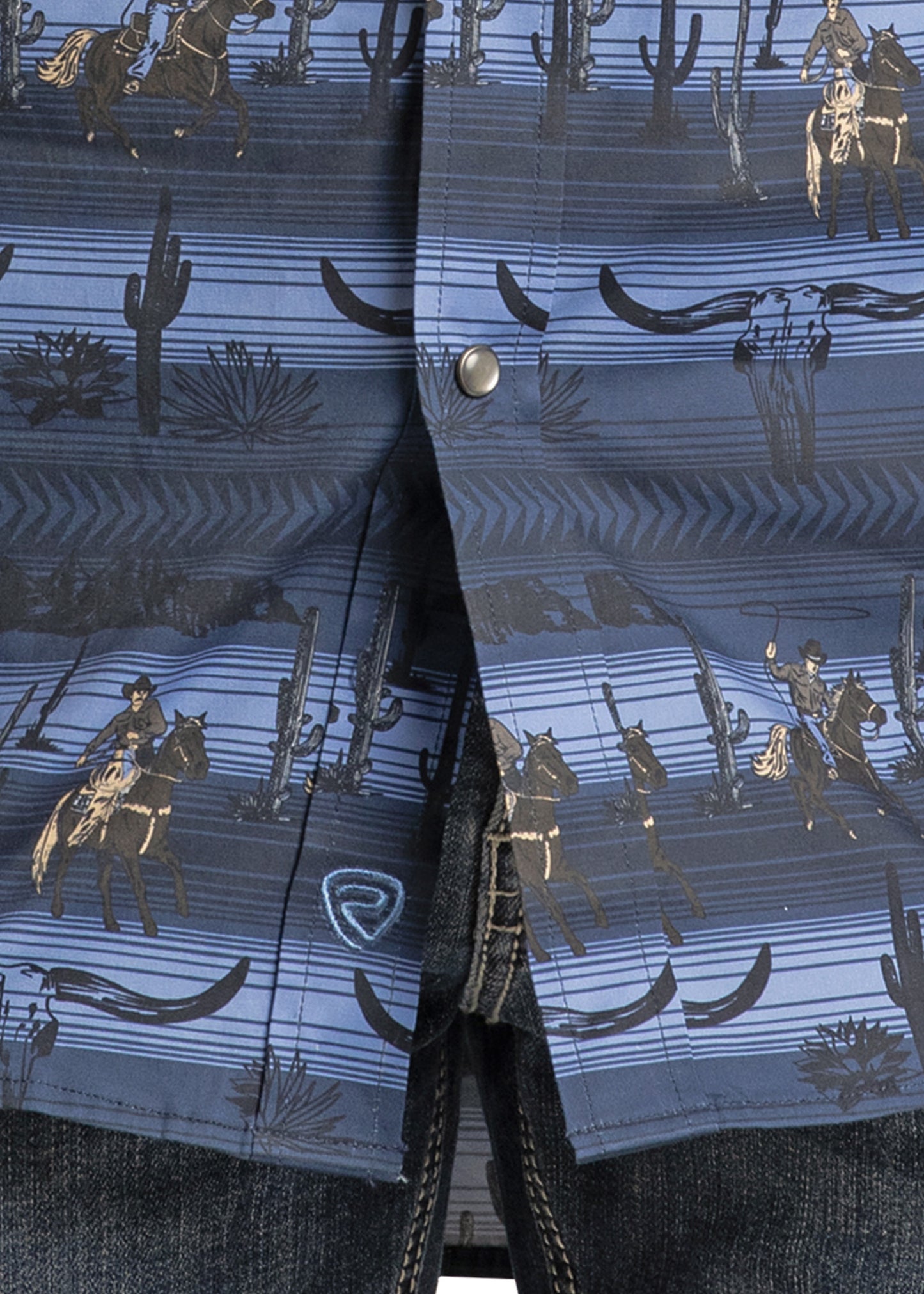 A close-up of the Rock & Roll Denim Slim Fit Longhorn Cowboy Long Sleeve Snap Shirt, showcasing a blue cowboy and cactus pattern with silver snaps, styled with dark denim jeans for a timeless Western look.
