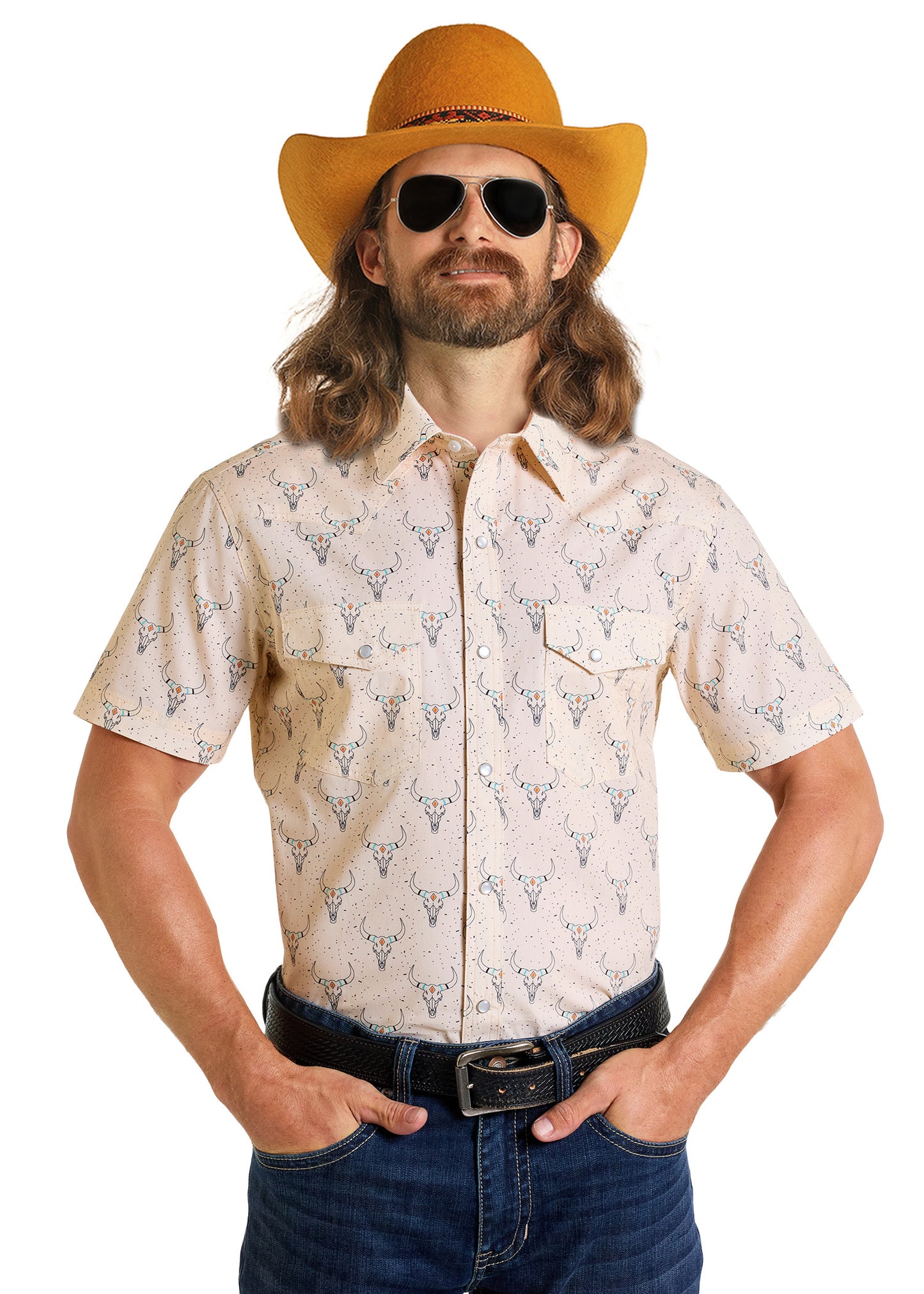 A man with long hair and a beard wears a yellow cowboy hat, black sunglasses, blue jeans, and a Dale Brisby Slim Fit Longhorn Print Short Sleeve Snap Shirt by Rock & Roll Denim, standing with hands in his pockets against a white background.