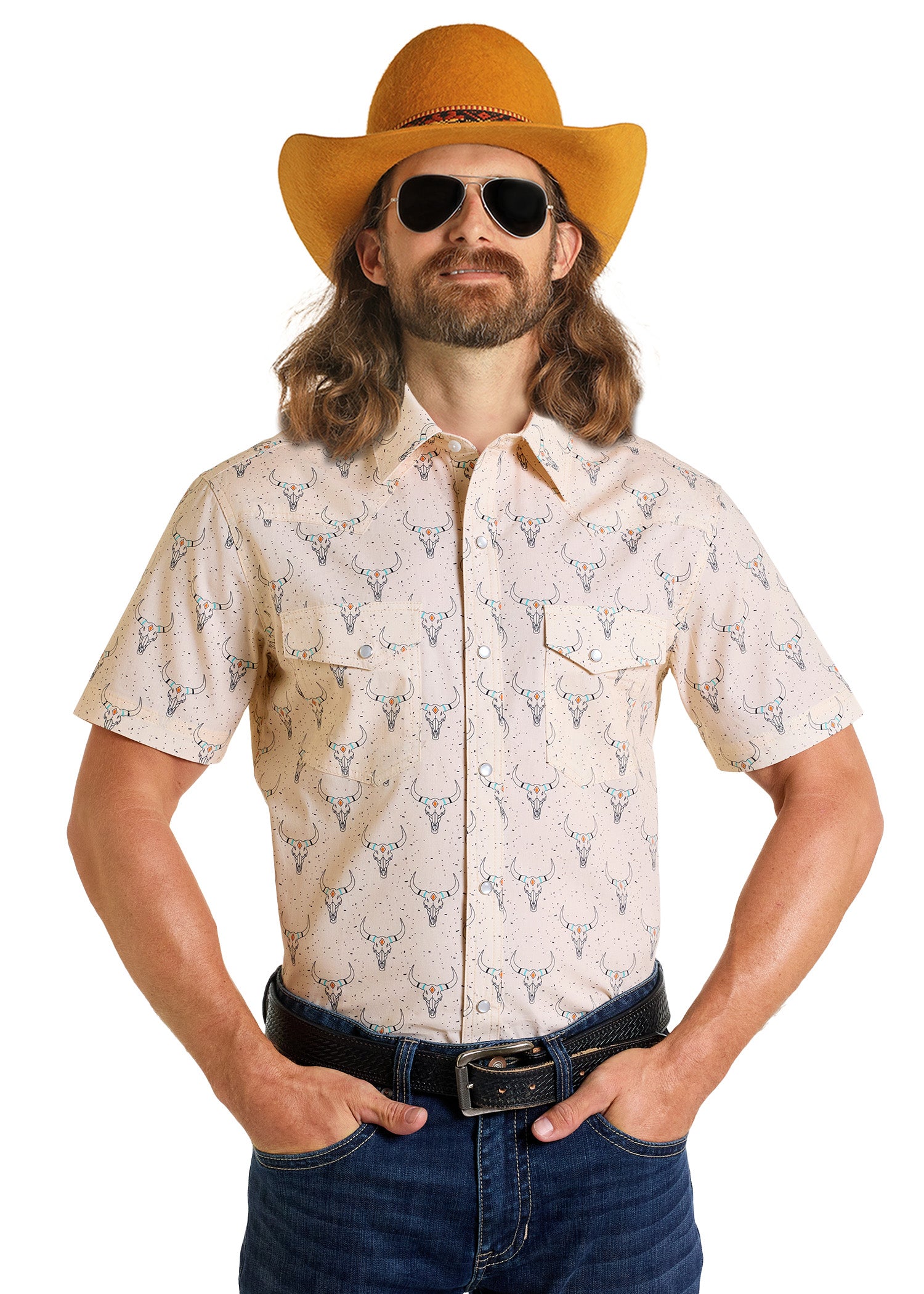 A man with long hair and a beard wears a yellow cowboy hat, black sunglasses, blue jeans, and a Dale Brisby Slim Fit Longhorn Print Short Sleeve Snap Shirt by Rock & Roll Denim, standing with hands in his pockets against a white background.